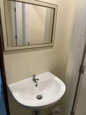 a white sink in a bathroom with a mirror at Nomad Yard Hostel in Bangkok