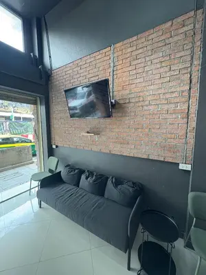 a living room with a couch against a brick wall at Nomad Yard Hostel in Bangkok