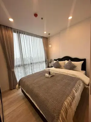 a bedroom with a large bed with a large window at The CLEV Riverline Chaophraya in Nonthaburi