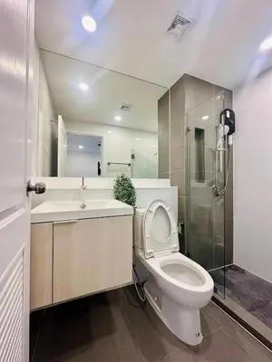 a bathroom with a toilet and a sink and a shower at The CLEV Riverline Chaophraya in Nonthaburi