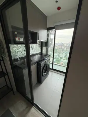 a kitchen with a sink and a washing machine at The CLEV Riverline Chaophraya in Nonthaburi