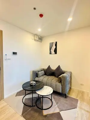 a living room with a couch and a table at The CLEV Riverline Chaophraya in Nonthaburi