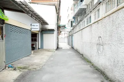 an alley way with a building with a garage at XX Mitr Inn Khaosan Street - มิตร อินน์ ตรอกข้าวสาร in Bangkok
