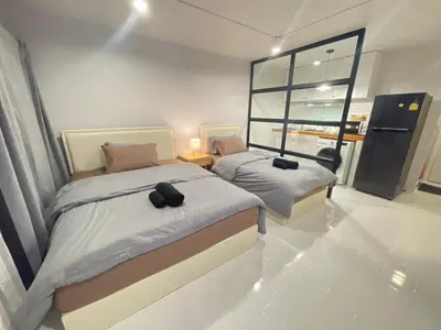 two beds in a room with a window at Lazy Nest at Impact Muangthong in Thung Si Kan