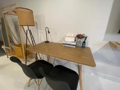 a wooden table with two chairs and a lamp at Lazy Nest at Impact Muangthong in Thung Si Kan