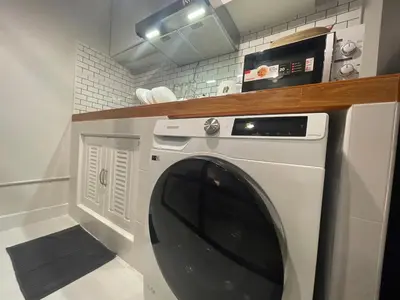 a washing machine in a kitchen with a counter at Lazy Nest at Impact Muangthong in Thung Si Kan