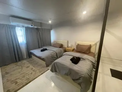 two beds in a small room with a window at Lazy Nest at Impact Muangthong in Thung Si Kan