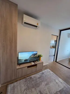 a living room with a flat screen tv on a wall at Modiz Modiza Sukhumvit R1 in Bangkok