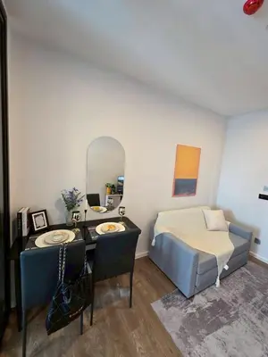 a bedroom with a bed and a desk and a mirror at Modiz Modiza Sukhumvit R1 in Bangkok