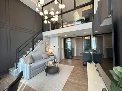 a living room with a couch and a staircase at Modiz Modiza Sukhumvit R2 in Bangkok