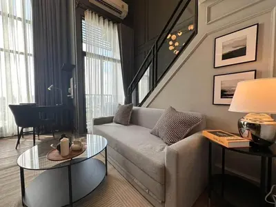 a living room with a couch and a table at Modiz Modiza Sukhumvit R2 in Bangkok