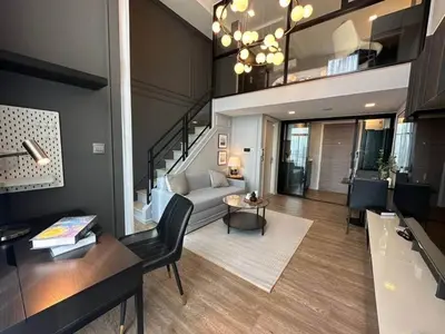 a large living room with a couch and a staircase at Modiz Modiza Sukhumvit R2 in Bangkok