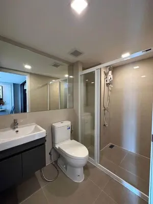 a bathroom with a toilet and a shower and a sink at Modiz Modiza Sukhumvit R2 in Bangkok