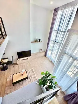 a living room with a couch and a tv at Modiz Modiza Sukhumvit R3 in Bangkok