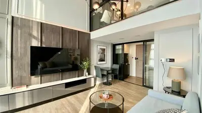 a living room with a couch and a tv at Modiz Modiza Sukhumvit R4 in Bangkok