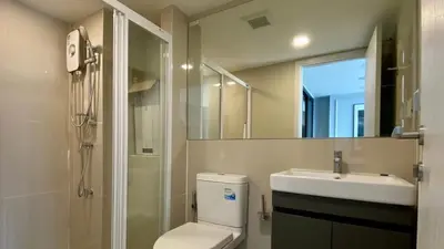 a bathroom with a toilet and a sink and a mirror at Modiz Modiza Sukhumvit R4 in Bangkok