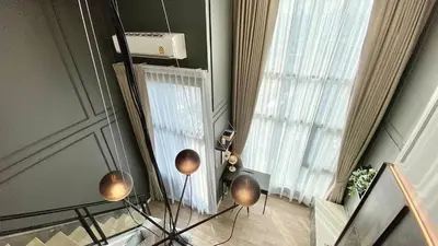 a room with a large window and a table with angth at Modiz Modiza Sukhumvit R4 in Bangkok