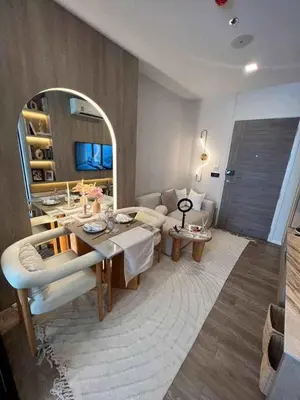 a living room with a table and a mirror at Modiz Modiza Sukhumvit R5 in Bangkok