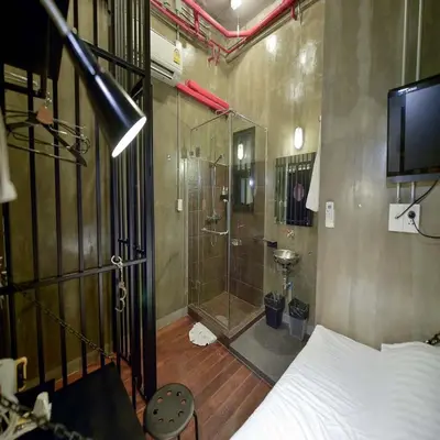 a bedroom with a shower and a bed and a television at Collection O Jasaen Stylish Unique Hotel in Bangkok