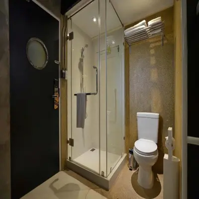 a bathroom with a glass shower and a toilet at Collection O Jasaen Stylish Unique Hotel in Bangkok