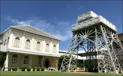 a building with a tower next to a house at xx Mitr Inn Khaosan มิตร อินน์ ตรอกข้าวสาร in Bangkok