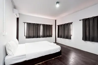 a bedroom with a white bed with black curtains at xx Mitr Inn Khaosan มิตร อินน์ ตรอกข้าวสาร in Bangkok