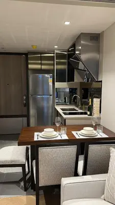 a kitchen with a table and chairs and a kitchen with a refrigerator at Luxury condominium Heart of BKK Ekkamai in Bangkok