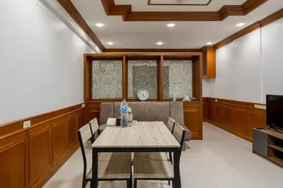 a dining room with a table and chairs and a tv at White Base in Bangkok