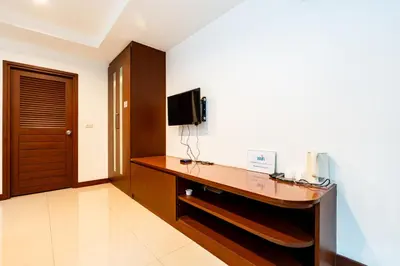 a room with a desk with a tv on a wall at XX Yon INN Sukhumvit Soi 4 - BTS Nana in Bangkok