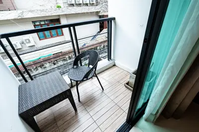 a balcony with a chair and a view of a train at XX Yon INN Sukhumvit Soi 4 - BTS Nana in Bangkok