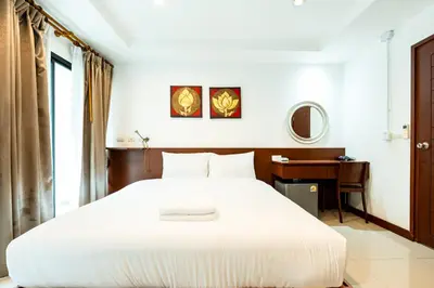 a bedroom with a large white bed and a desk at XX Yon INN Sukhumvit Soi 4 - BTS Nana in Bangkok