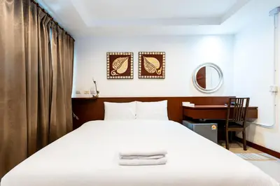 a bedroom with a white bed and a desk at XX Yon INN Sukhumvit Soi 4 BTS Nana in Bangkok