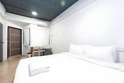 a bedroom with a large white bed and a door at xx Yellow Place Sukhumvit Soi 2 - เยลโล เพลส สุขุมวิทซอย 2 in Bang Kapi