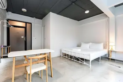 a bedroom with a bed and a table and a desk at xx Yellow Place Sukhumvit Soi 2 - เยลโล เพลส สุขุมวิทซอย 2 in Bang Kapi