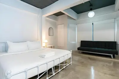 a bedroom with a white bed and a black couch at xx Yellow Place Sukhumvit Soi 2 - เยลโล เพลส สุขุมวิทซอย 2 in Bang Kapi