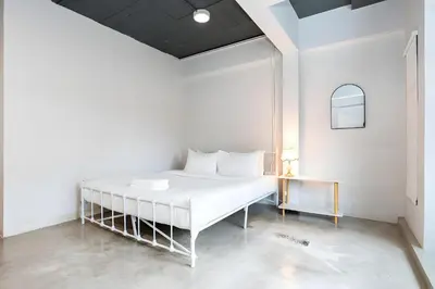 a white bedroom with a white bed and a table at xx Yellow Place Sukhumvit Soi 2 - เยลโล เพลส สุขุมวิทซอย 2 in Bang Kapi