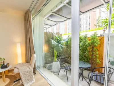 a room with a balcony with a table and chairs at Studio room with private garden in Center Sathorn in Bangkok
