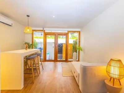 a living room with a bed and a kitchen at Studio room with private garden in Center Sathorn in Bangkok