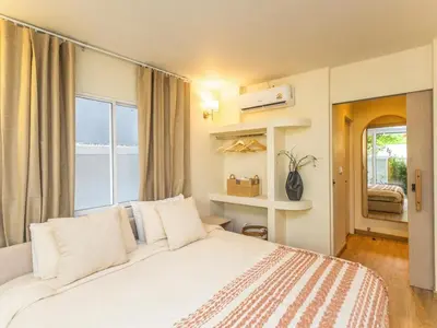 a bedroom with a large white bed and a window at Studio room with private garden in Center Sathorn in Bangkok