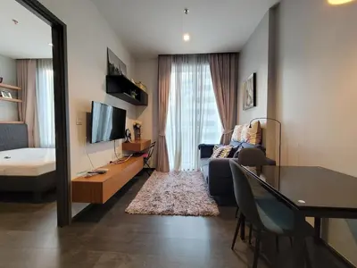 a living room with a couch and a table and a television at Downtown Luxury Apartment, Asok Cowboy Lane, 400m from BTS in Bangkok