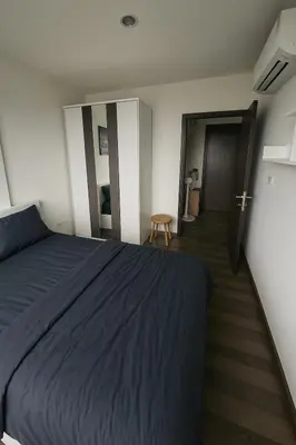a bedroom with a blue bed and a hallway at 1 Bedroom Bangkok Skyline View Apartment At ON-NUT in Bangkok