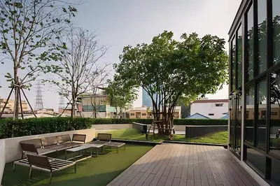 a patio with benches and tables in a building at Skyline View 1 Bedroom Near RCA, Thonglor And Nana in Bangkok