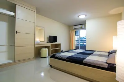 a bedroom with a bed and a sliding glass door at Dae Ma Place in Nonthaburi