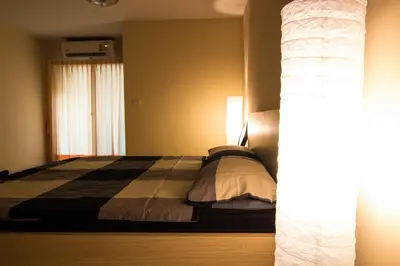 a bedroom with a bed and a window at Dae Ma Place in Nonthaburi