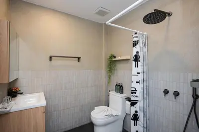 a bathroom with a toilet and a shower at Urban Muji Oasis Ratchada-Lat Phrao Chatuchak MRT in Bangkok