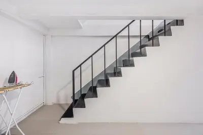 a staircase in a white room with black railings at Bangkok Group Haven - 6BR Bangchak BTS 12 sleeps RB4 in Amphoe Phra Khanong