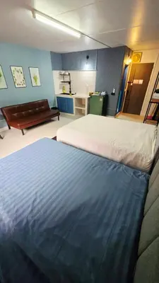 a bedroom with two beds and a couch in a room at อิมแพ็ค เมืองทองธานี ห้องเช่ารายวัน เมืองทอง popular condo C4 in Nonthaburi