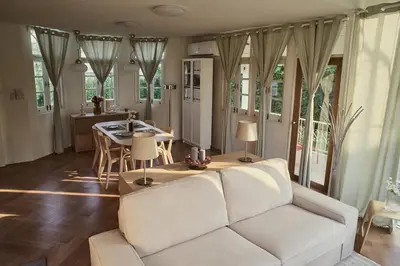 a living room with a white couch and a table at Baan Suanpak in Bangkok