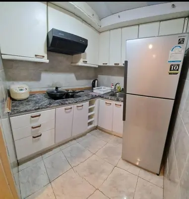 a kitchen with white cabinets and a refrigerator at Comfort 1BR 2 King Beds, Best Value Stay, near Bts Nana in Bangkok