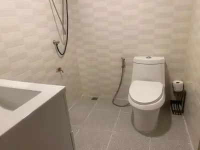 a white bathroom with a toilet and a sink at 1 Bed Nr IKEA 15Mins to Airport in Bangkok